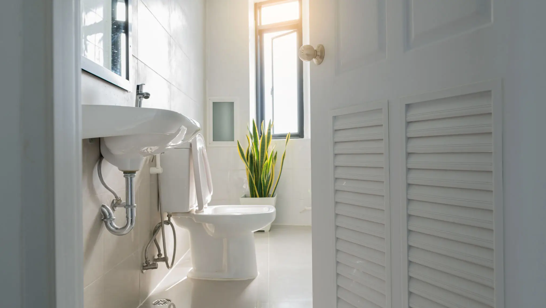 Plumber repairing a bathroom sink fixture — minor plumbing and electrical repairs by JKV Contractors